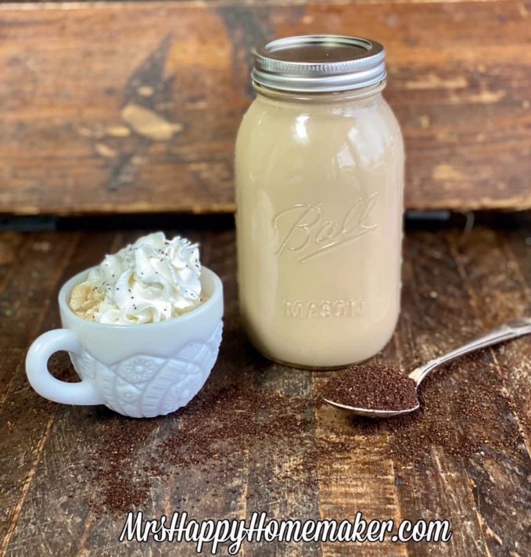 Make ahead lattes - one in a mason jar and one in a white cup topped with whipped cream. There is a spoon with coffee grounds in it beside of it