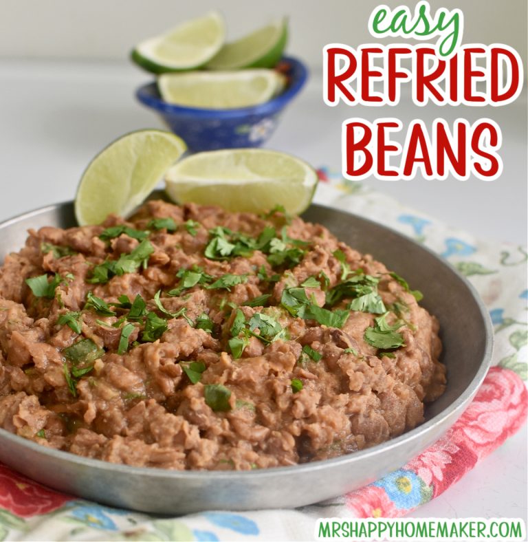 Easy homemade refried beans in a round silver dish on a floral tea towel