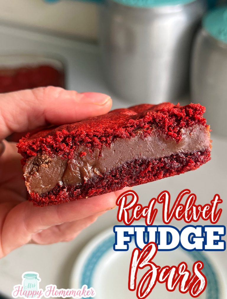 Red Velvet Fudge Bars being held in a hand over a blue rimmed white plate